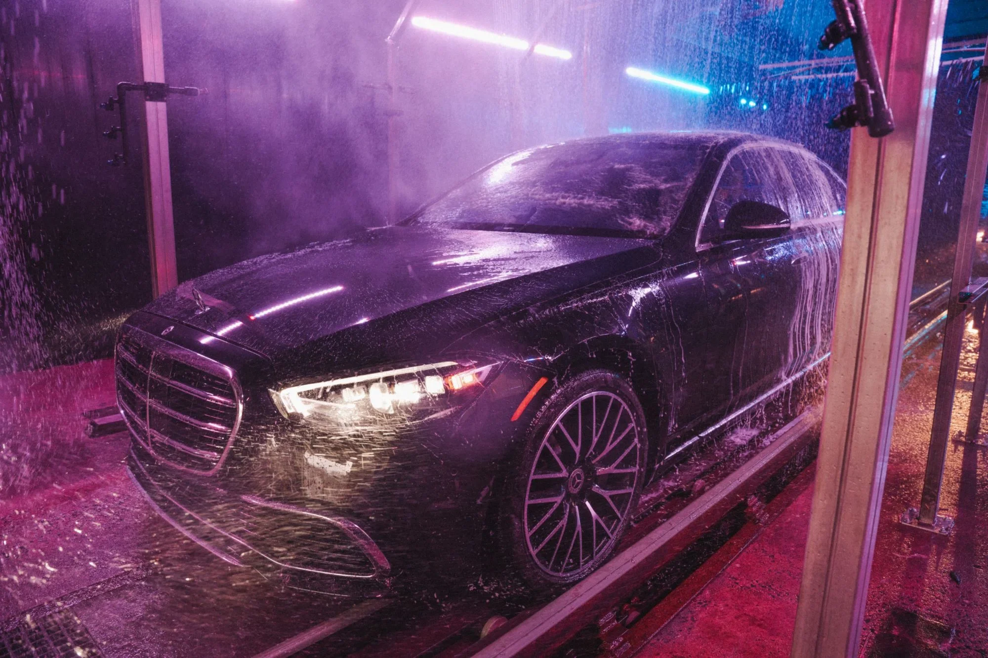 A black sedan under the spray arches in the Luxe tunnel, headlights on